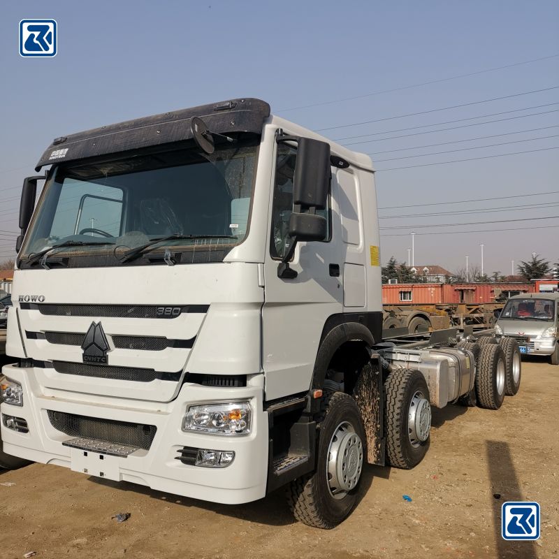 Side view of white HOWO 6x6 cargo truck showcasing the tire profile and the driver's cabin with air conditioning unit on top.