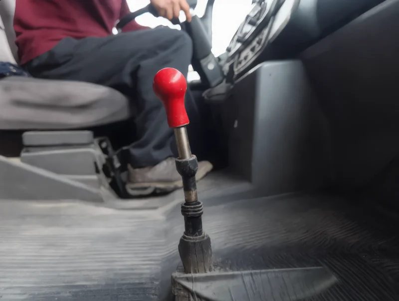 Shacman truck gear lever in a cab, hand on the knob during a range change